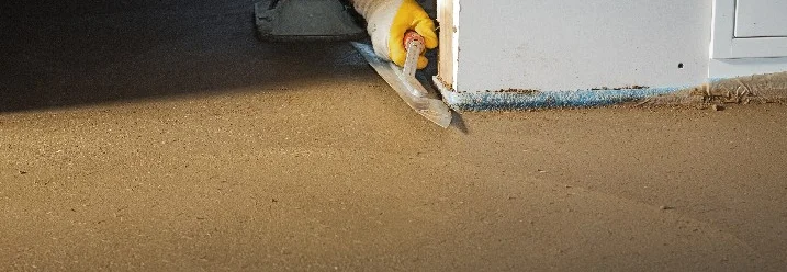 Person glättet Estrich mit Glättkelle